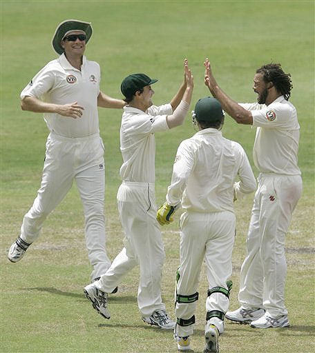 Australia's Beau Casson high fives with teammate Andrew Symonds as wicketkeeper Brad Haddin and Stuart Clark looks on, after Casson caught out West Indies batsman Xavier Marshall for 39 runs on the on the second day of their third and final Test at Kensington Oval in Bridgetown, Barbados on June 13, 2008. Day 2: Aus vs WI, 3rd Test